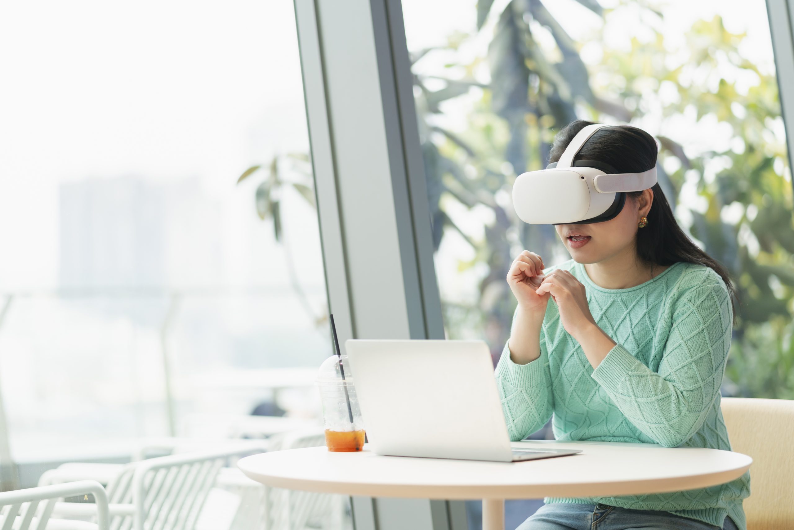 smart-attractive-asian-female-business-owner-weared-virtual-reality-glasses-enjoys-casual-metaverse-meeting-with-concentrate-at-cafe-restaurantasian-female-using-oculus-rift-headset-in-cafe-scaled.jpg